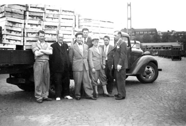 Herman Nilsson och medarbetare uppställda framför en fullastad lastbil vid Ilgodskajen 1952