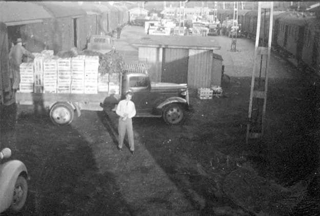 Lastbil fylld med trälådor lastas om mellan godsvagnar vid Ilgodskajen 1951