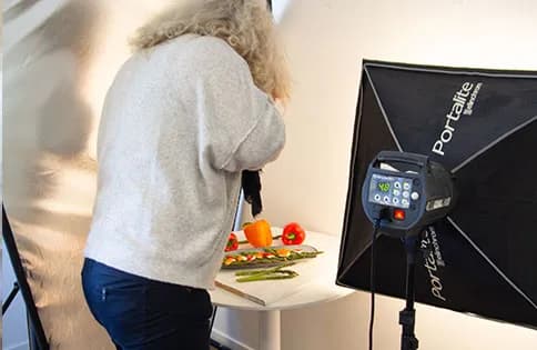 Anita fotograferar paprika och sparris i fotostudion