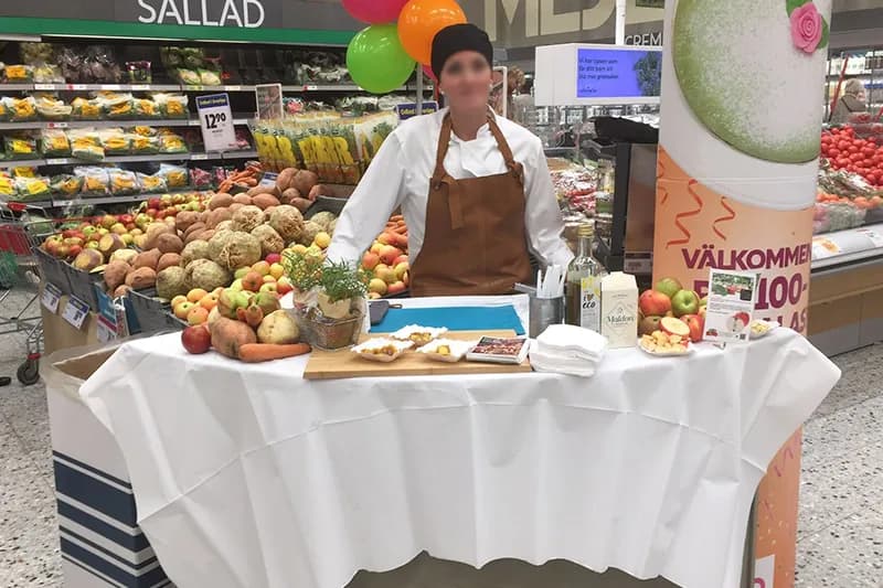 Produktdemonstration med svenska äpplen och rotfrukter i butik