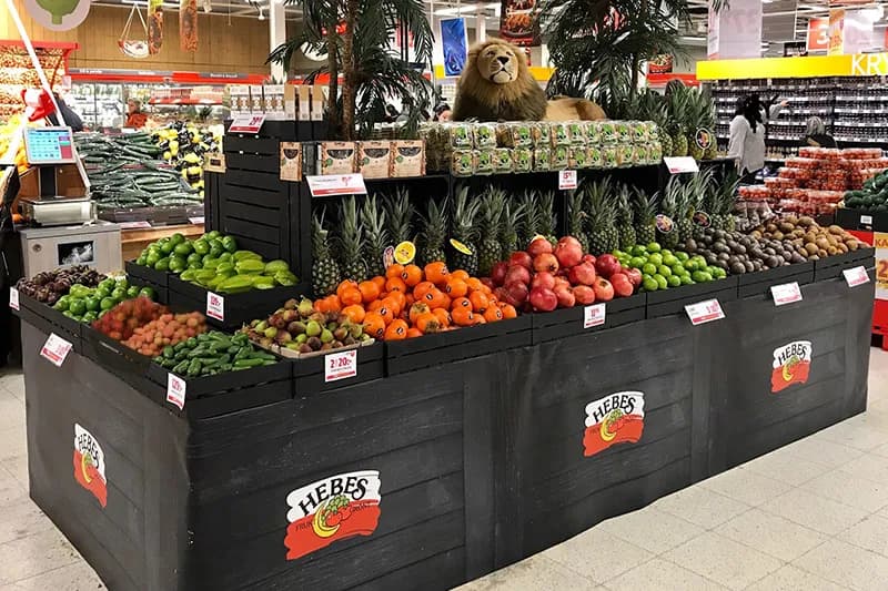 Exotisk exponering med carambole, sharon och ananas i svarta trälådor